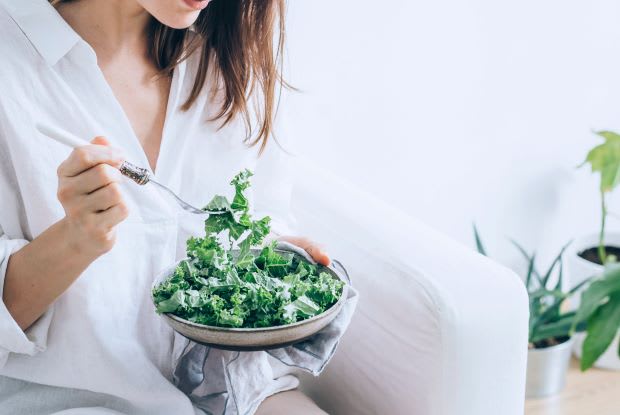 a person eating a bowl of kale