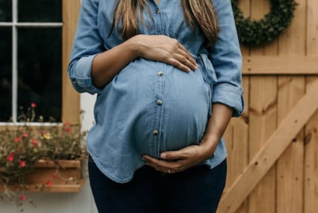 a pregnant woman holding her stomach