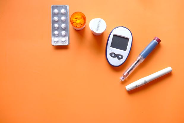 a blood sugar monitor on an orange background