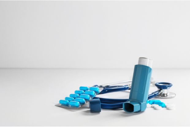 inhaler, tablets, and stethoscope on table