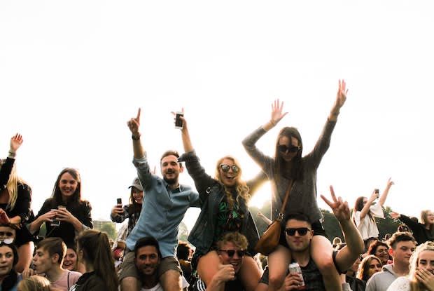 men and women waving their hands in the air