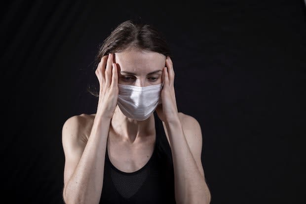 a woman looking concerned while wearing a mask