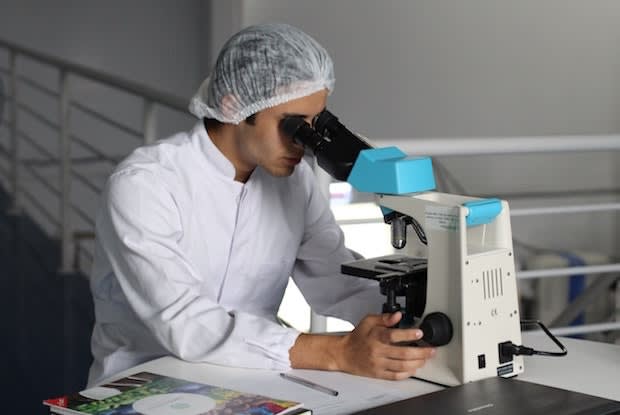 a man looking into a microscope