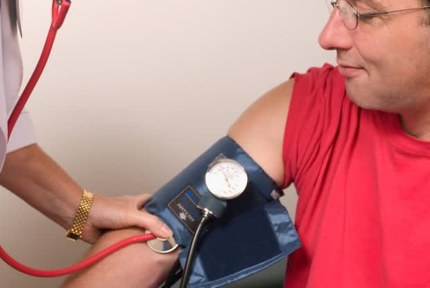 a doctor taking a man’s blood pressure reading