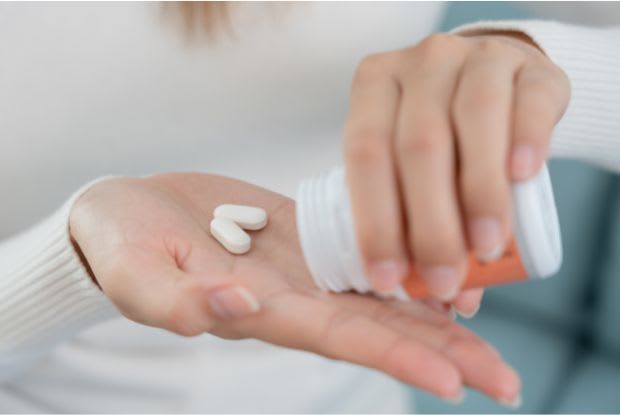 a woman taking Entresto tablets