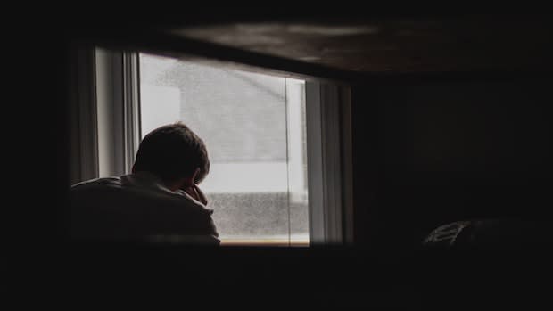 a person looking outside a gray window