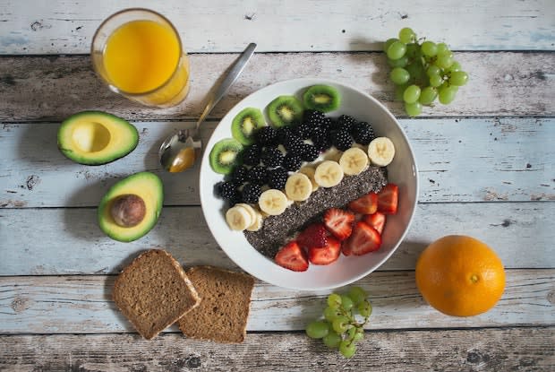 a healthy fruit bowl, avocado, and wheat toast