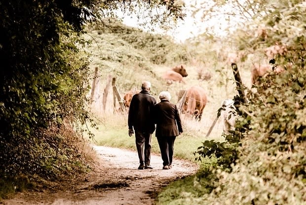 an older man and woman walking