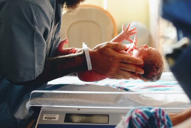 doctors weighing a baby on a scale