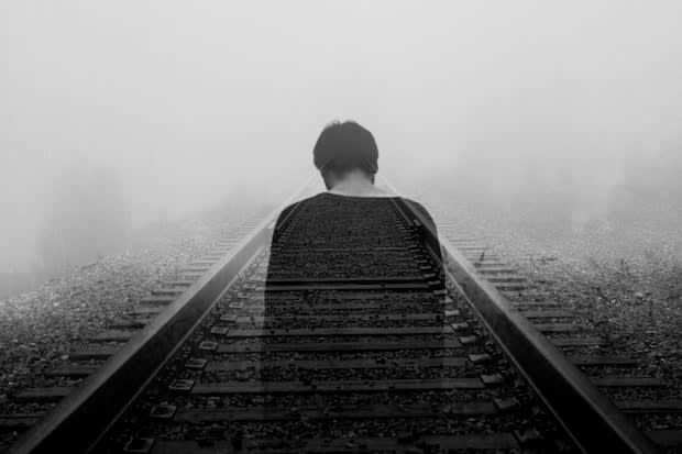 a man walking in the middle of train tracks