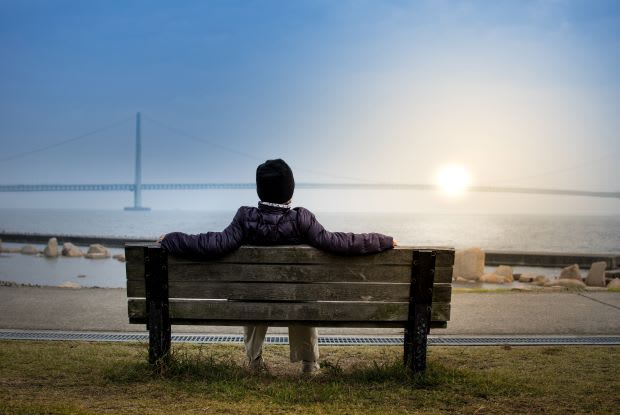 a person sitting on a bench overlooking the ocean