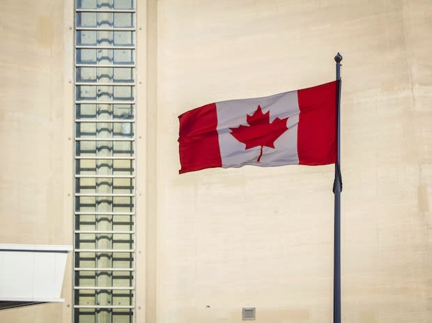 a Canadian flag on a flag pole