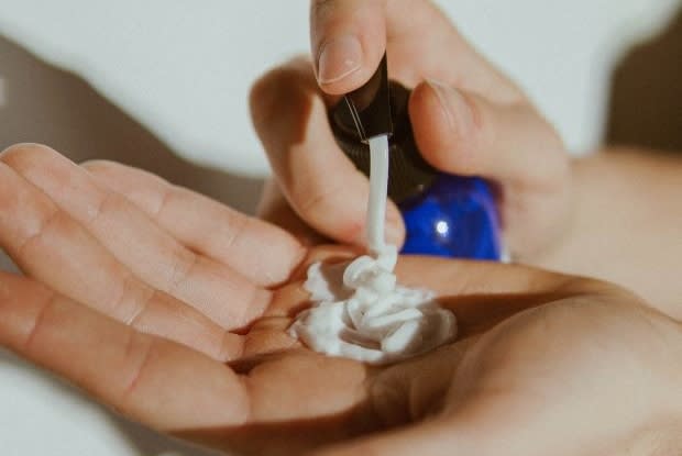 two hands dispensing shampoo