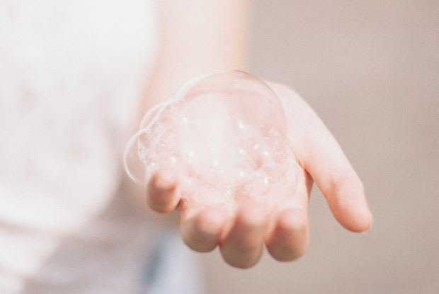 a hand holding a soap bubble