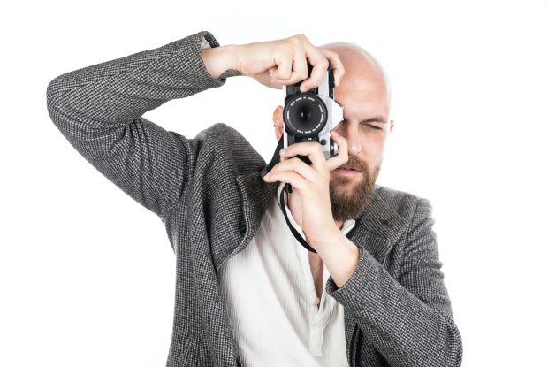 a bald man with a camera