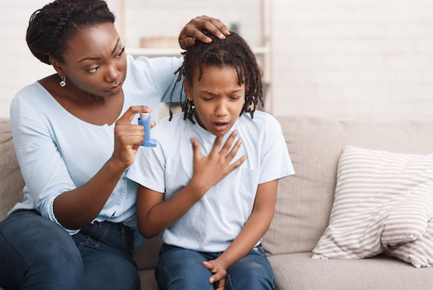 a woman helping her son with an inhaler