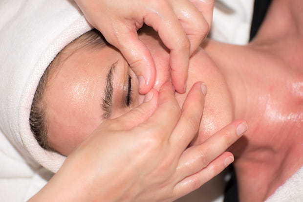 a woman getting her face massaged