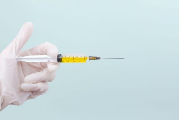 a hand holding an injection needle