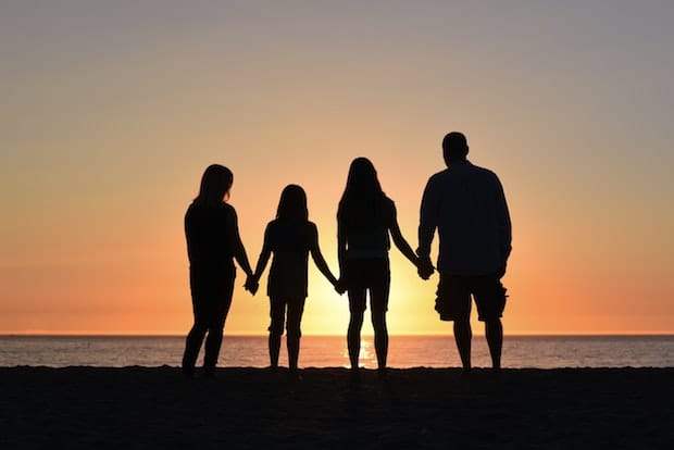 a family holding hands in the sunset