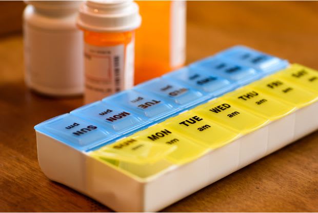 medication bottles and a pill container on a table