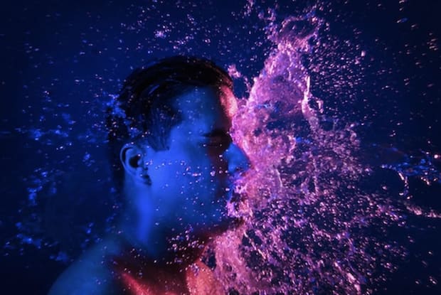 a man splashing water on his face