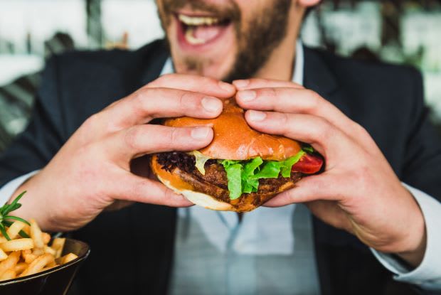 a man eating a cheeseburger