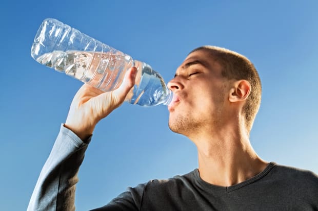 man drinking water from a bottle