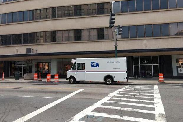 USPS van parked outside of a building