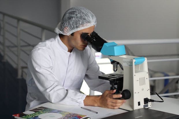 a man looking through a microscope