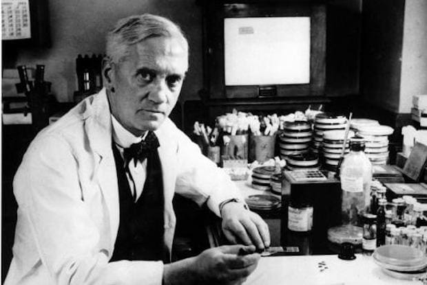 A black and white photo of Alexander Fleming with scientific equipment