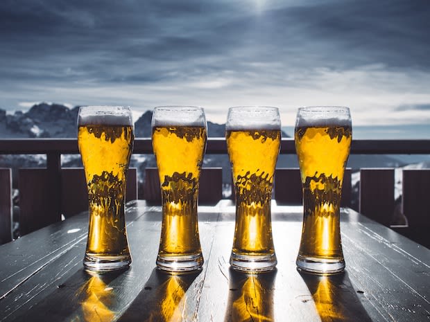 Four glasses of beer on a table outside