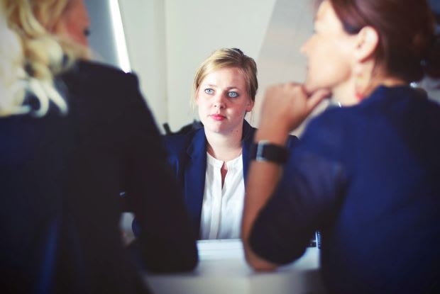 a young woman sitting in between two other women