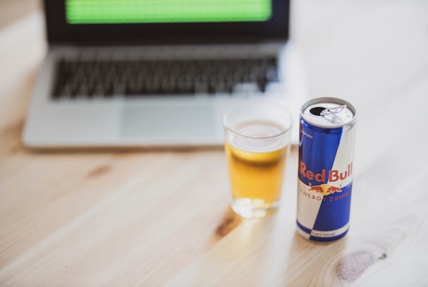 a red bull next to a laptop