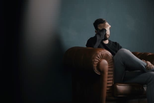 a depressed man sitting on a sofa