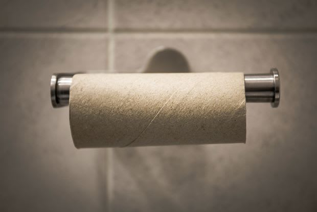 an empty toilet paper roll on its dispenser