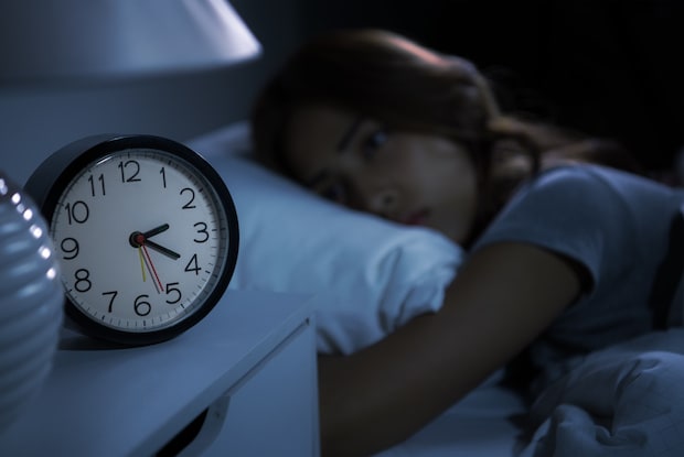 a woman struggling to fall asleep due to an altered circadian rhythm