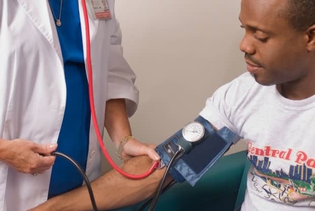 a doctor taking a man’s blood pressure reading