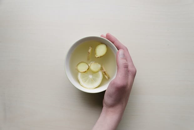 a cup full of tea and ginger pieces