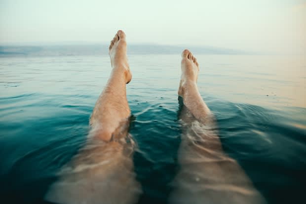 a person with their legs in a body of water