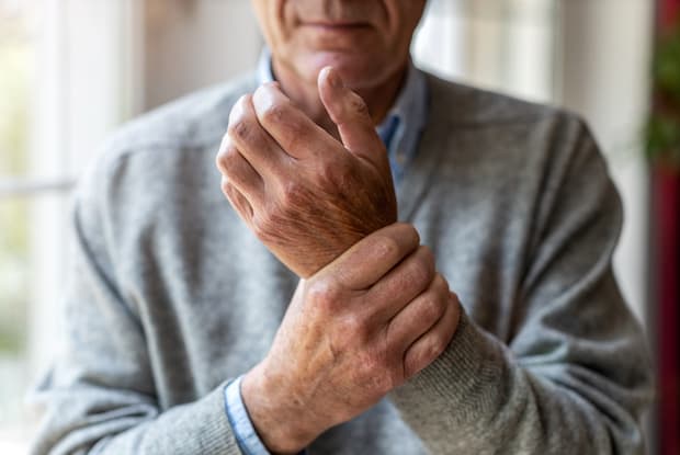 a man clutching his hand in pain