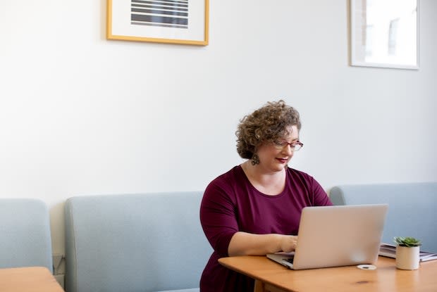 a woman seated in front of her laptop