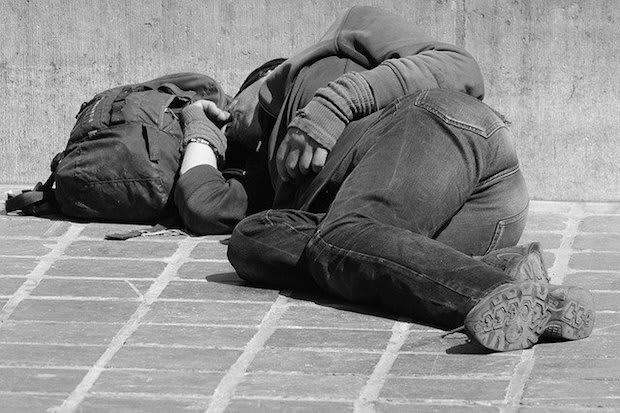 a man laying down on the ground outside