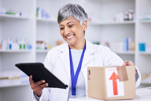 A pharmacist packing an online medication order for delivery