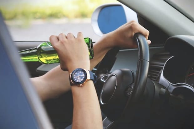 A person drinking alcohol while driving