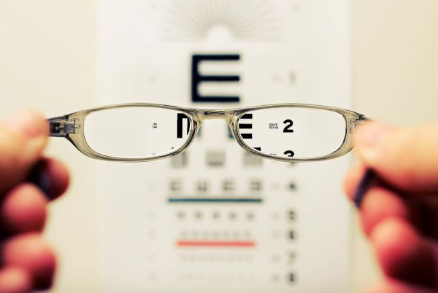 glasses being held up in front of a vision test