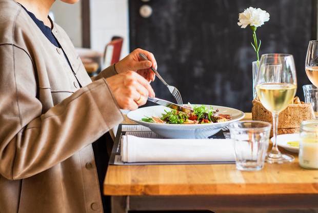 a person eating a salad at a restaurant