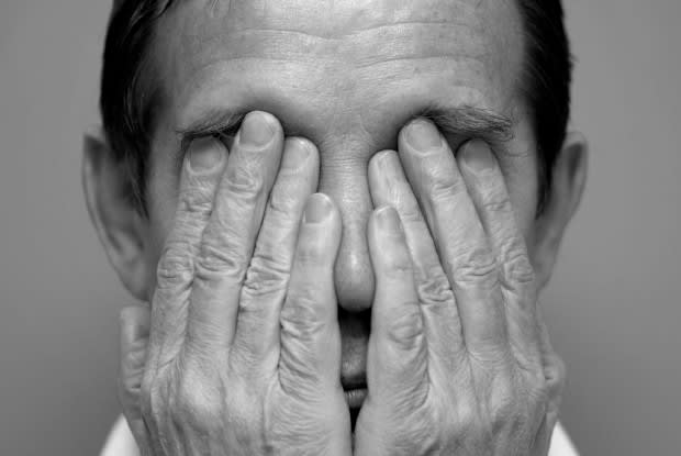 a man rubbing his eyes due to eye pain