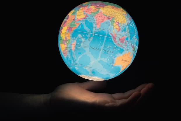 a hand holding a globe