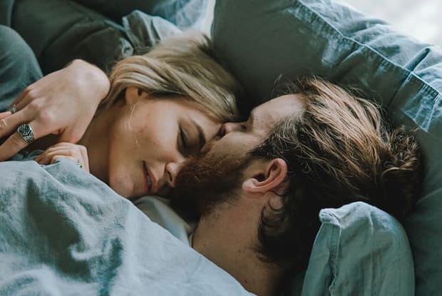 a man and a woman being intimate in bed