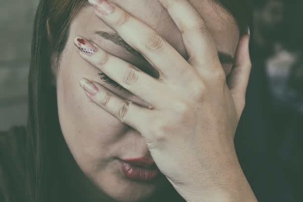 a woman with her hand to her face